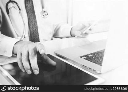 Medical technology concept. Doctor hand working with modern digital tablet and laptop computer with medical chart interface, black white
