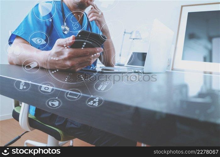 Medical technology concept.Doctor hand working with smart phone and laptop with digital tablet computer in modern clinic office with virtual screen medical chart interface