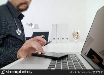 Medical technology concept. Doctor hand working with smart phone,laptop,modern digital tablet dock screen computer in modern clinic office room