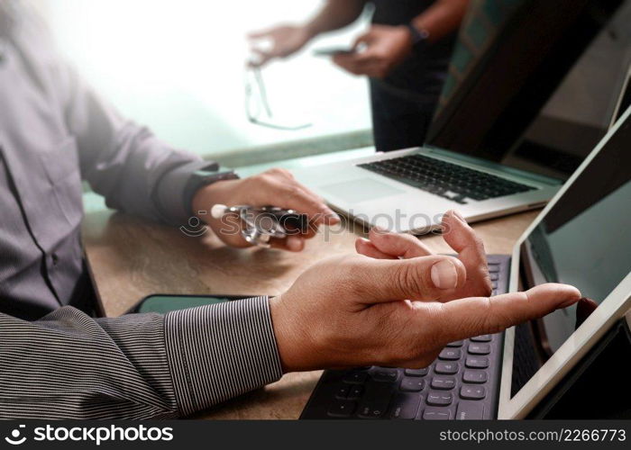 Medical technology network team meeting concept. Doctor hand working smart phone keyboard docking digital tablet screen laptop computer.sun flare effect