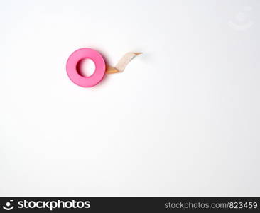 medical textile adhesive plaster for skin in a twisted, pink plastic packaging on a white background