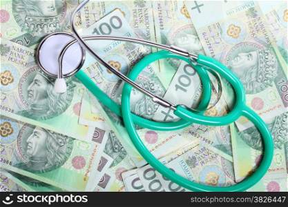 medical treatment and high cost for a good health care service concept: green stethoscope on money polish zloty paper banknotes