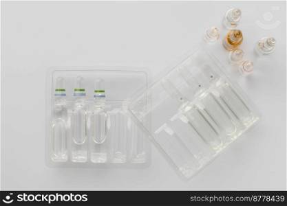 Medical vials with liquid for injection in plastic containers on a white background. The view from the top. tablets on a light background