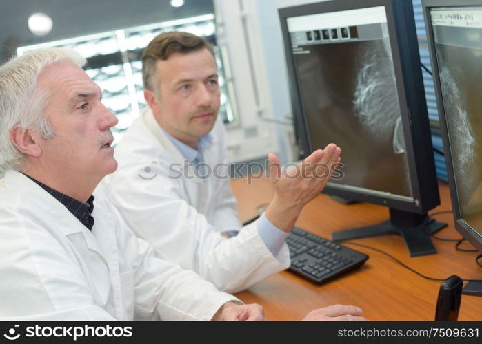 Medical workers looking at results on computer screen