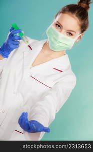 Medication and cure. Injection concept. Young woman doctor holding syringe. Female specialist with mask on face and vaccine in hand.. Professionalist in mask with syrigne