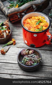 Medicinal flower tea. iron mug with herbal decoctions of clover and marigolds