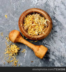 Medicinal herbs. Dried calendula flowers in mortar. Dried calendula flowers