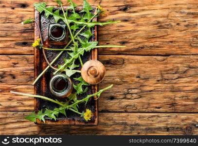 Medicinal plant dandelion or Taraxacum officinale.Herbal medicine.Healing herbs on wooden table. Dandelion tincture in bottle