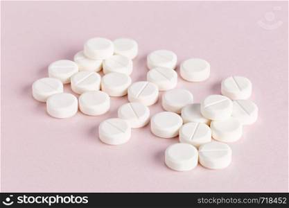 Medicinal round tablets on a pink background. Medicinal round pills on a pink background