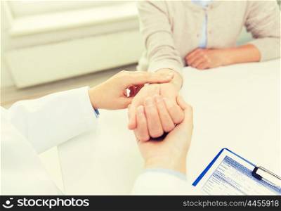 medicine, age, health care and people concept - close up of doctor or nurse checking senior woman pulse at hospital ward