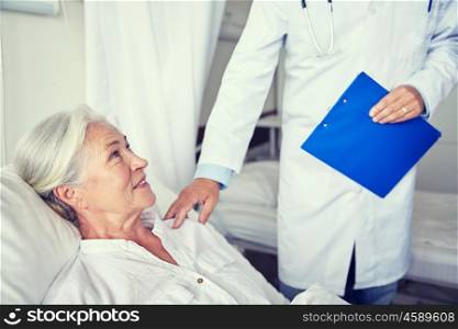 medicine, age, health care and people concept - doctor visiting happy senior woman at hospital