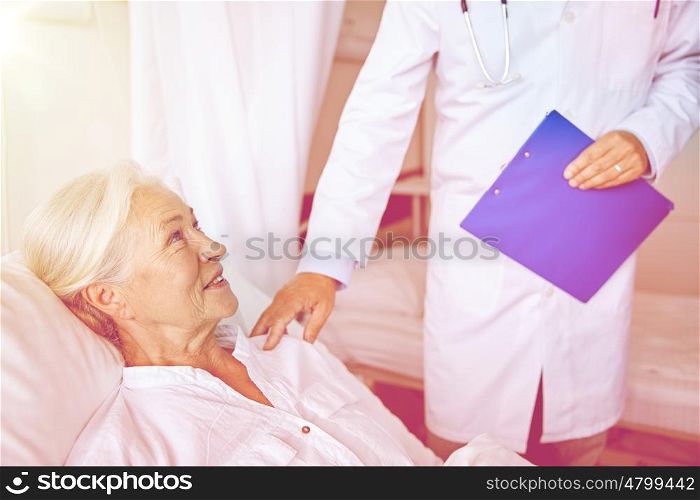 medicine, age, health care and people concept - doctor visiting happy senior woman at hospital