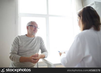 medicine, age, health care and people concept - senior man and doctor meeting in medical office at hospital. senior man and doctor meeting at hospital