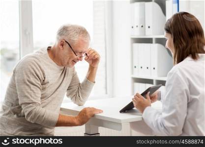 medicine, age, health care and people concept - senior man and doctor with tablet pc computer meeting in medical office at hospital. senior man and doctor with tablet pc at hospital