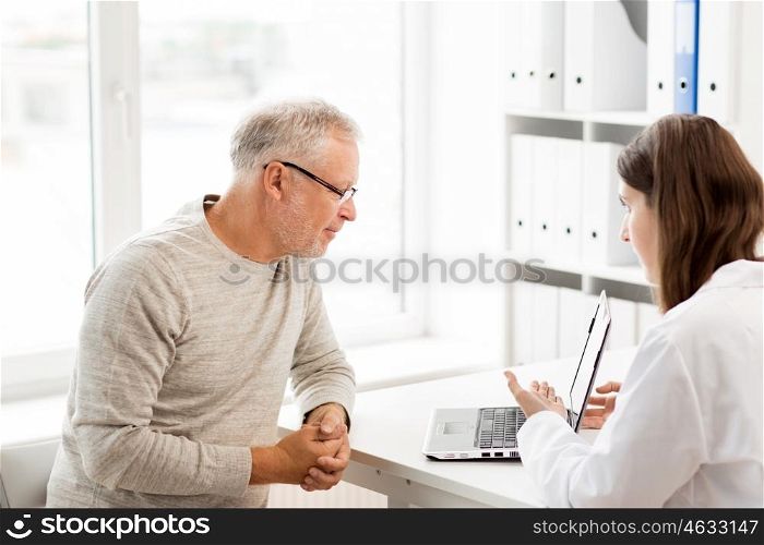 medicine, age, health care and people concept - senior man and doctor with laptop computer meeting in medical office at hospital