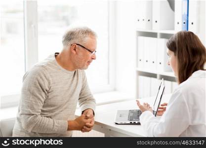 medicine, age, health care and people concept - senior man and doctor with laptop computer meeting in medical office at hospital