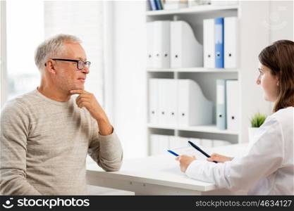 medicine, age, health care and people concept - senior man and doctor with clipboard meeting and talking in medical office at hospital