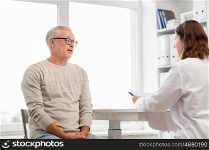 medicine, age, health care and people concept - senior man and doctor with clipboard meeting and talking in medical office at hospital