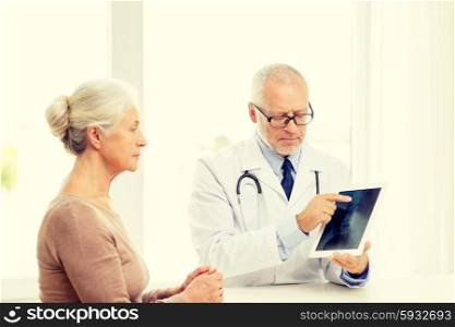 medicine, age, health care and people concept - senior woman and doctor with tablet pc computer meeting in medical office