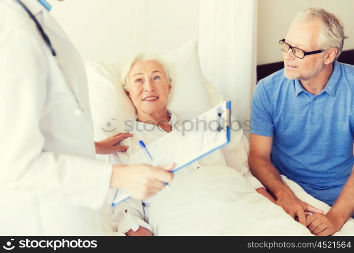 medicine, age, health care and people concept - senior woman, man and doctor with clipboard at hospital ward