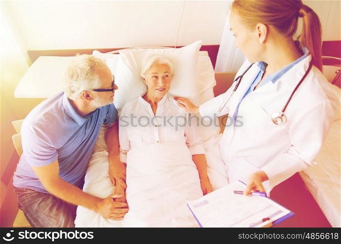 medicine, age, health care and people concept - senior woman, man and doctor with clipboard at hospital ward