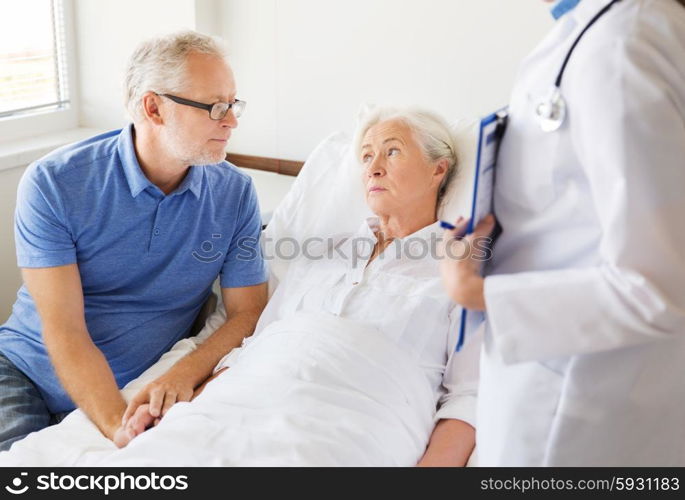 medicine, age, health care and people concept - senior woman, man and doctor with clipboard at hospital ward