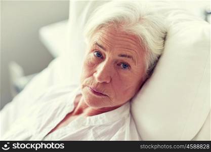 medicine, age, health care and people concept - senior woman patient lying in bed at hospital ward