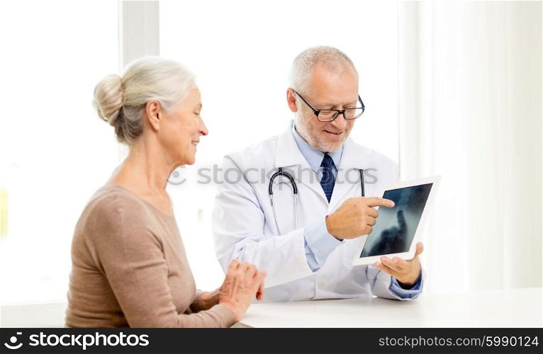 medicine, age, health care and people concept - smiling senior woman and doctor with tablet pc computer meeting in medical office