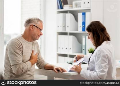medicine, age, health care, cardiology and people concept - senior man and doctor with cardiogram on clipboard meeting in medical office at hospital