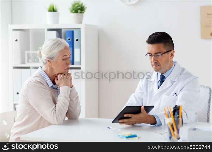 medicine, age, healthcare and people concept - senior woman and doctor with tablet pc computer meeting at hospital. senior woman and doctor with tablet pc at hospital