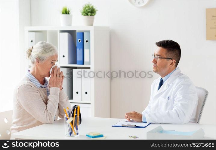 medicine, age, healthcare and people concept - senior woman and doctor with clipboard meeting at hospital. senior woman and doctor meeting at hospital