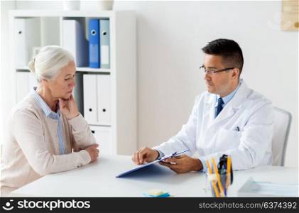 medicine, age, healthcare and people concept - senior woman and doctor with clipboard meeting at hospital. senior woman and doctor meeting at hospital