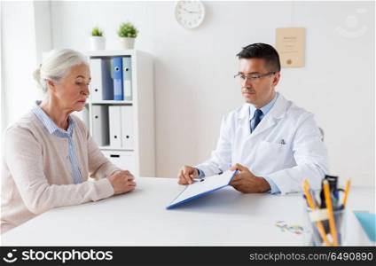 medicine, age, healthcare and people concept - senior woman and doctor with clipboard meeting at hospital. senior woman and doctor meeting at hospital. senior woman and doctor meeting at hospital
