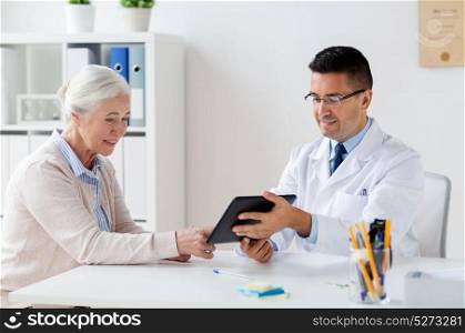 medicine, age, healthcare and people concept - smiling senior woman and doctor with tablet pc computer meeting at hospital. senior woman and doctor with tablet pc at hospital