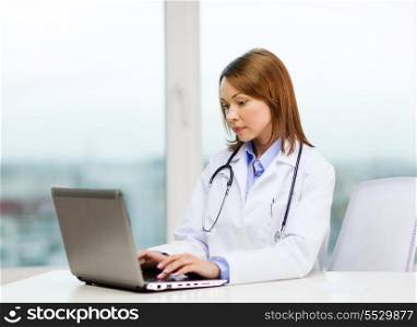 medicine and healthcare concept - busy doctor with laptop computer