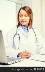 medicine and healthcare concept - busy doctor with laptop computer