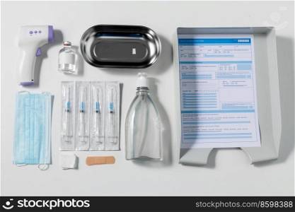 medicine and healthcare concept - close up of syringes, mask, hand sanitizer and other medical stuff on table at hospital. syringes, mask, sanitizer and other stuff on table
