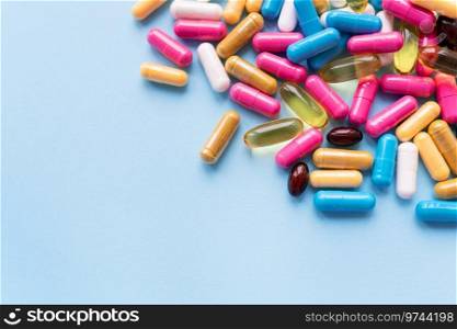 Medicine and healthcare concept. Macro shot of colorful bright tablets and capsules on a blue background. Place for an inscription. Medicine and healthcare concept. Macro shot of colorful bright tablets and capsules on a blue background. Place for an inscription.