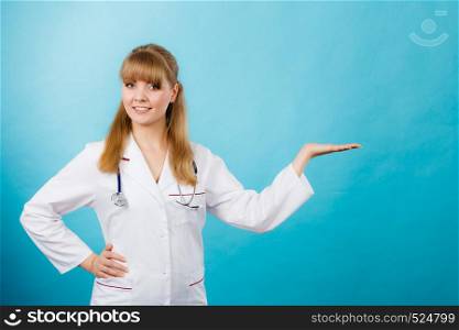 Medicine and healthcare. Portrait of young smiling female doctor. Woman professionalist in white medical uniform showing copy space.. Young female professional doctor showing copy space.