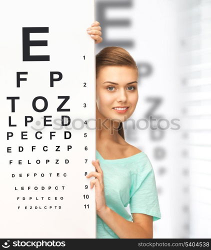 medicine and vision concept - woman in eyeglasses with eye chart