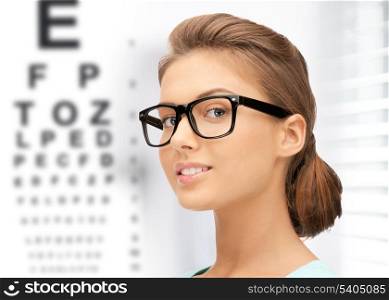 medicine and vision concept - woman in eyeglasses with eye chart