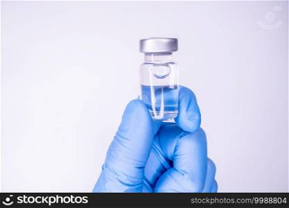 Medicine bottle for injection in hand, palm of a doctor. Medical glass vial for vaccination. Science equipment, liquid drug or vaccine from treatment, flu in laboratory, hospital or pharmacy.