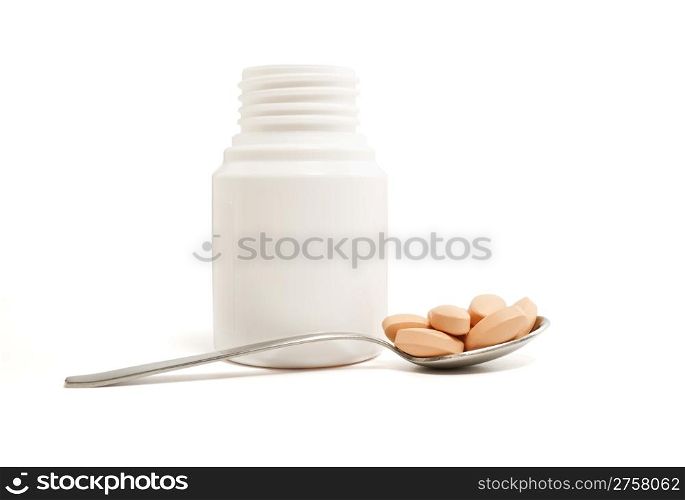 medicine bottle, spoon and pills on white background