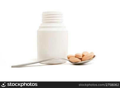 medicine bottle, spoon and pills on white background