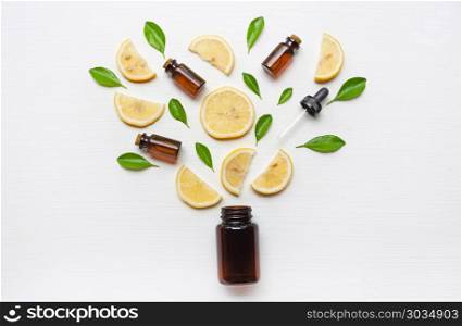Medicine bottle with fresh lemon slices and leaf on white.. Medicine bottle with fresh lemon slices and leaf on white wooden background.