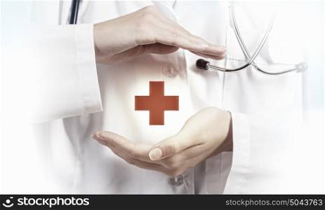 Medicine cross symbol. Female doctor in white showing medicine cross sign