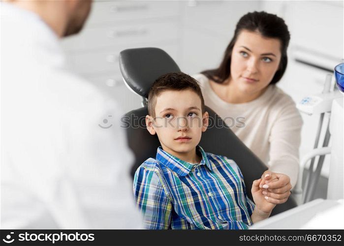 medicine, dentistry and healthcare concept - mother and son visiting dentist at dental clinic. mother and son visiting dentist at dental clinic. mother and son visiting dentist at dental clinic