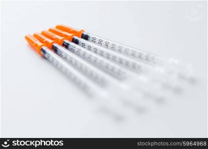 medicine, diabetes and health care concept - close up of insulin syringes on table