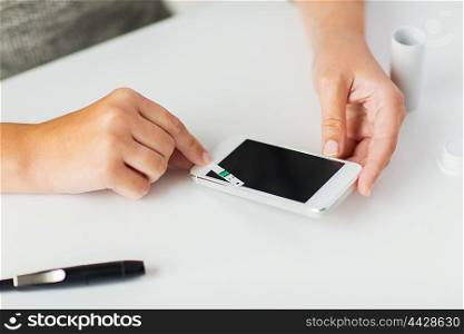 medicine, diabetes, glycemia, health care and people concept - close up of woman hands with smartphone checking blood sugar level by glucometer at home