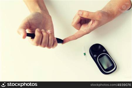 medicine, diabetes, glycemia, health care and people concept - close up of woman checking blood sugar level by glucometer at home. close up of woman making blood test by glucometer